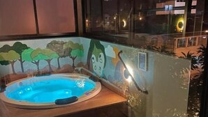 A hot tub with a wooden bench, surrounded by a glass wall with a mural of trees and a face. - Hospedaria da Lagoa (Florianópolis)