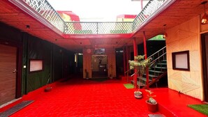 Corredor com carpete vermelho, escada, paredes de madeira e um balcão.