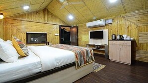 Quarto com cama, televisão, armário e ventoinha no teto.