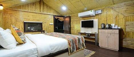 Una habitación con cama, televisor, armario y ventilador de techo.