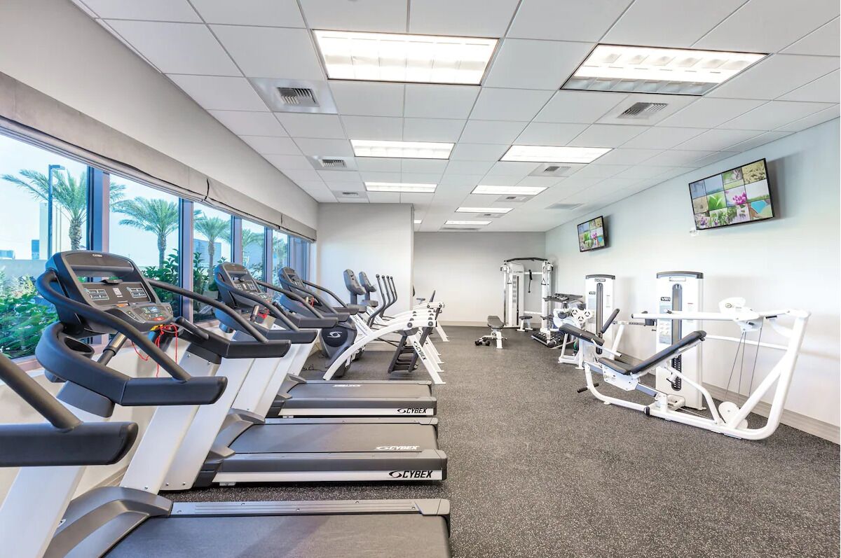 A gym with treadmills, elliptical machines, and weight equipment.