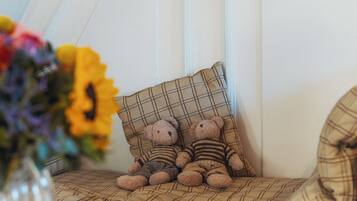 Een gezellige zithoek met een ruitkussen en twee teddyberen.