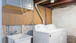 Un espace buanderie équipé d’un lave-linge et d’un évier.