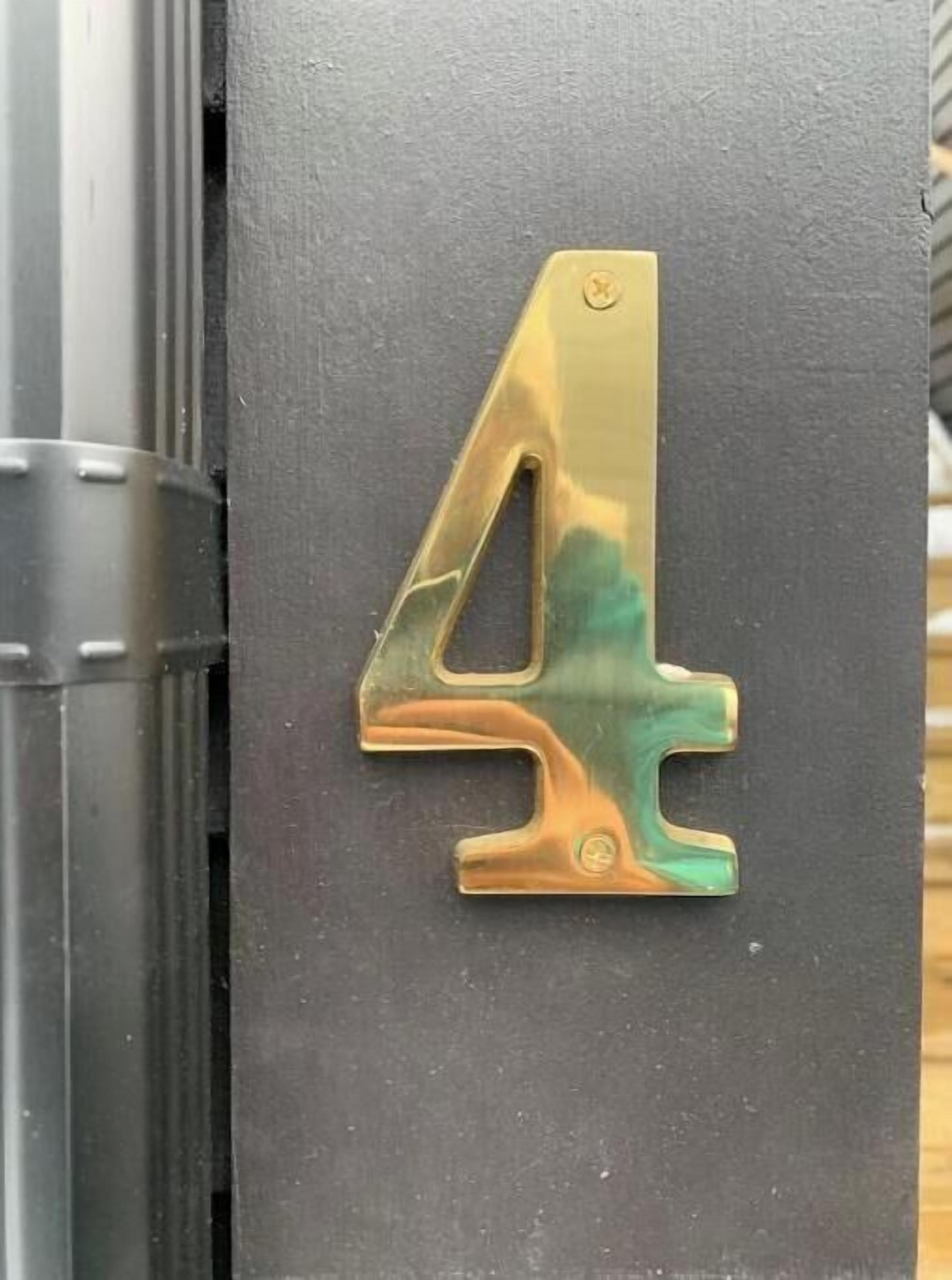 A black door with a gold number '4' sign.