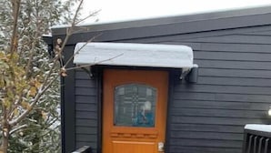 A wooden deck leading to a dark wooden door with a glass panel. - Urban Luxury Loft: Parking+72”TV (Burlington)
