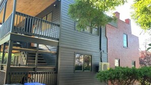 A two-story building with a balcony on the upper level. - Petite+Perfect Modern Pad: parking+laundry+yard (Burlington)