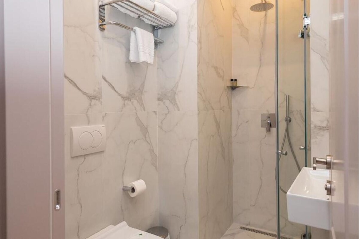 Un baño moderno con inodoro, ducha y lavamanos.