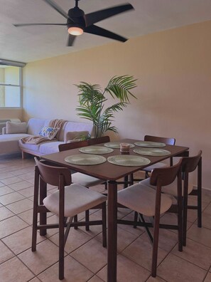 A dining area with a round table, chairs, and a ceiling fan. - #4 Beach Apt 2BR, 2BA - Jobos, Montones, Shacks (Isabela)