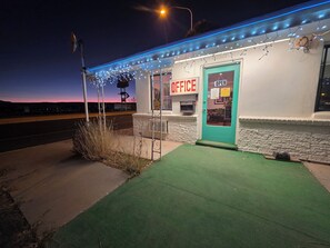 A building with a sign reading "OFFICE" and another sign indicating it is open. - Southwest Motel (Grants)