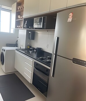 Departamento Deluxe | Cocina privada | Refrigerador con congelador, microondas y parrilla de estufa