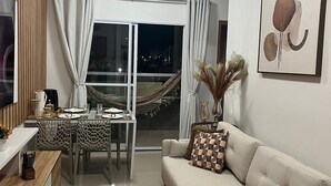 Ein modernes Wohnzimmer mit einer Couch, einem Esstisch und einem Fernseher.