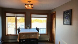 A dining area with a table and chairs, large windows, and a painting on the wall. - Beautiful waterfront home nestled on 4acres on Indian Lake!
A perfect getaway!
 (Whiting)