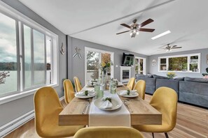 Un comedor con una mesa de madera, sillas amarillas y un sofá gris.