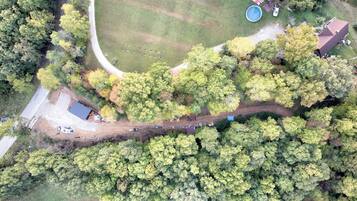 Vista aérea de una propiedad con piscina, zona vallada y camino de acceso.