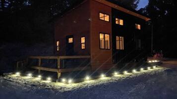 A modern building with a wooden deck and a series of lights along the front.