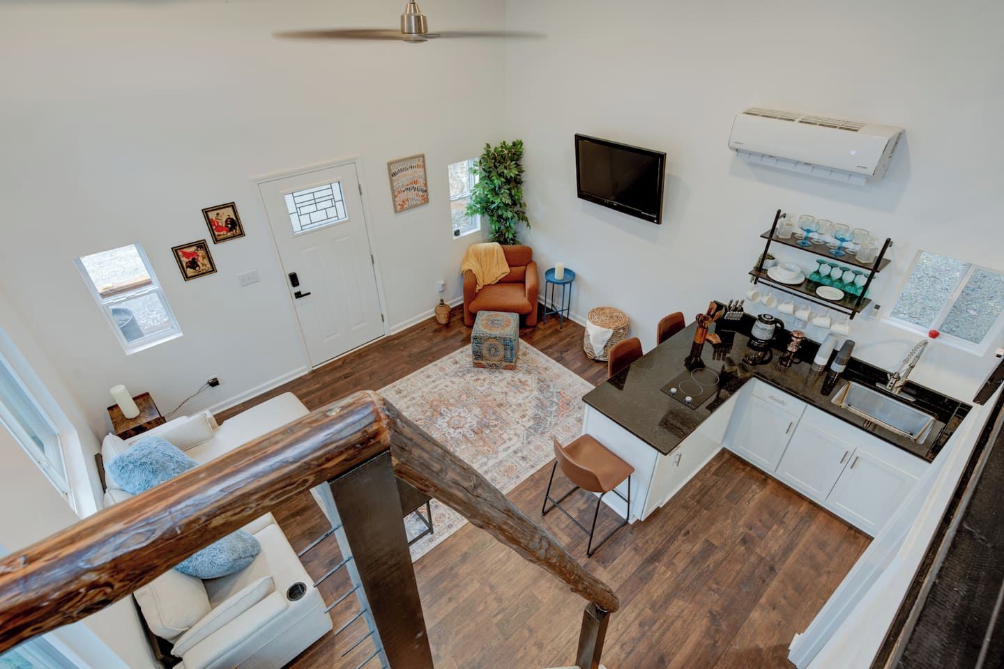 A compact living space with a kitchenette, a dining area, and a seating area with a sofa and chairs.