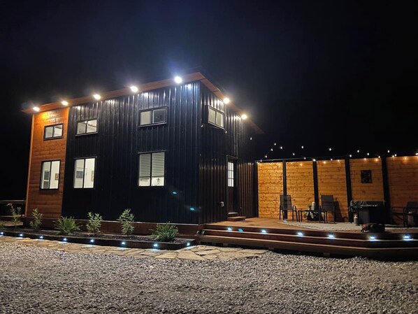A modern building with a wooden exterior and a balcony area with seating.