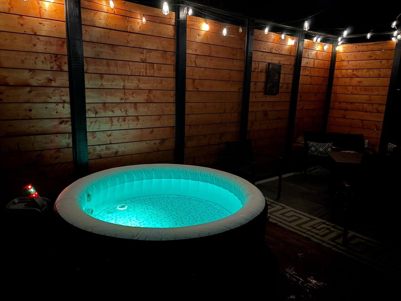 A hot tub in a wooden room with string lights.