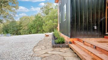A modern building with a stone pathway leading to a wooden deck.
