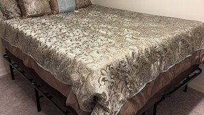 A single bed with a patterned bedspread, a headboard, and a footboard. - Charming 1-bedroom house rain Stone Mountain with WiFi access (Stone Mountain)