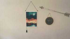 A room with a wooden floor, a white wall, a hanging artwork of a mountain landscape, and a round chalkboard with the name "Rafi J". - Charming 1-bedroom house rain Stone Mountain with WiFi access (Stone Mountain)