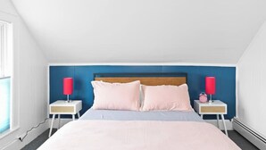 Ein Schlafzimmer mit einem Bett, zwei Nachttischen und einem Fenster.