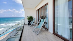A balcony with two lounge chairs, a potted plant, and a view of the ocean. - Beatiful Penthouse with Private Pool & Breathtaking Ocean Views in Isla Mujeres (Isla Mujeres)