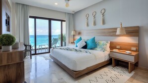 A modern bedroom with a large bed, a ceiling fan, a nightstand, and a view of the ocean. - Beatiful Penthouse with Private Pool & Breathtaking Ocean Views in Isla Mujeres (Isla Mujeres)