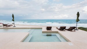 A pool area with lounge chairs and umbrellas, overlooking the ocean. - Beatiful Penthouse with Private Pool & Breathtaking Ocean Views in Isla Mujeres (Isla Mujeres)