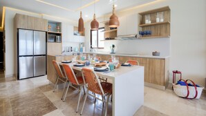 A modern kitchen with a central island, built-in appliances, and pendant lighting. - Beatiful Penthouse with Private Pool & Breathtaking Ocean Views in Isla Mujeres (Isla Mujeres)