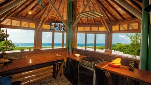 A kitchen with a view of the ocean, a stove, and a sink. - Cabañas Cochapunko I Espectacular vista 360 (Salango)