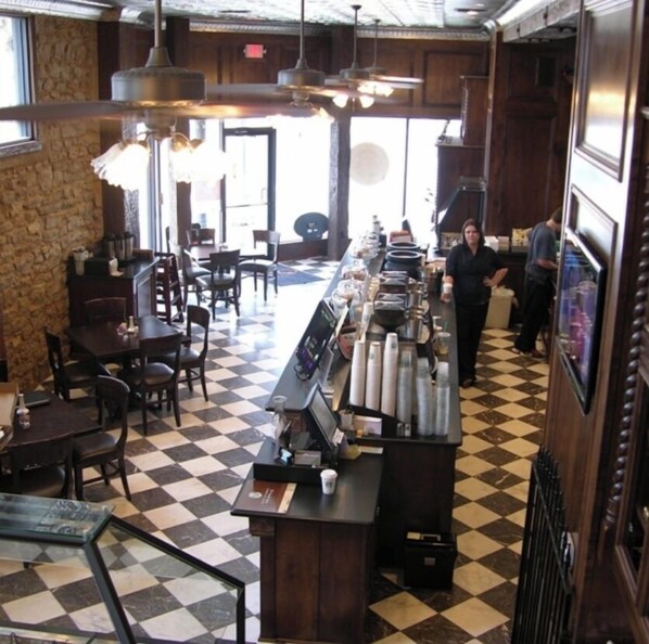 A restaurant with a checkered floor, wooden furniture, and hanging pendant lights. - Eastburn Inn (Jacksboro)