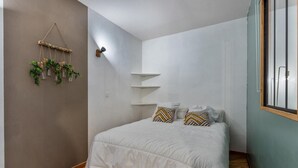 A bedroom with a bed, white bedding, two pillows, a wall-mounted plant, and a window with blinds. - 40m from ski slopes, 3rd floor, fitness, swimming pool, sauna, balcony, tv, ski locker, 39m² (Les Orres)