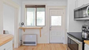 Une cuisine compacte équipée d’un four à micro-ondes, d’un four traditionnel et d’une petite fenêtre.
