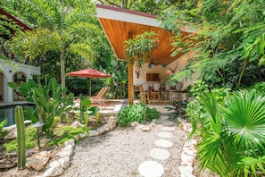 Un jardin avec une piscine, un espace salon extérieur et une pergola en bois.