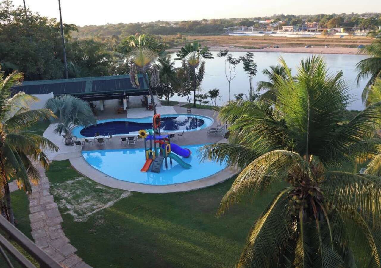 Zona de piscina con tobogán y puente sobre el agua.