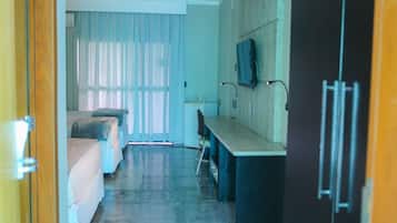 Ein Hotelzimmer mit einem Bett, einem Schreibtisch, einem Stuhl, einem Fernseher und einem Kleiderschrank.