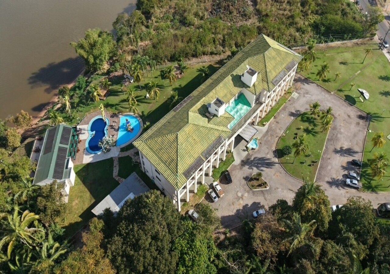 Um grande edifício com piscina, quadra de tênis e estacionamento.