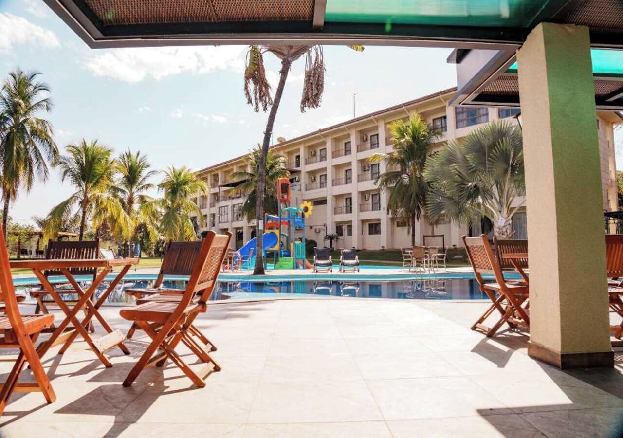 Un área junto a la piscina con sillones de descanso y una zona de juegos para niños.