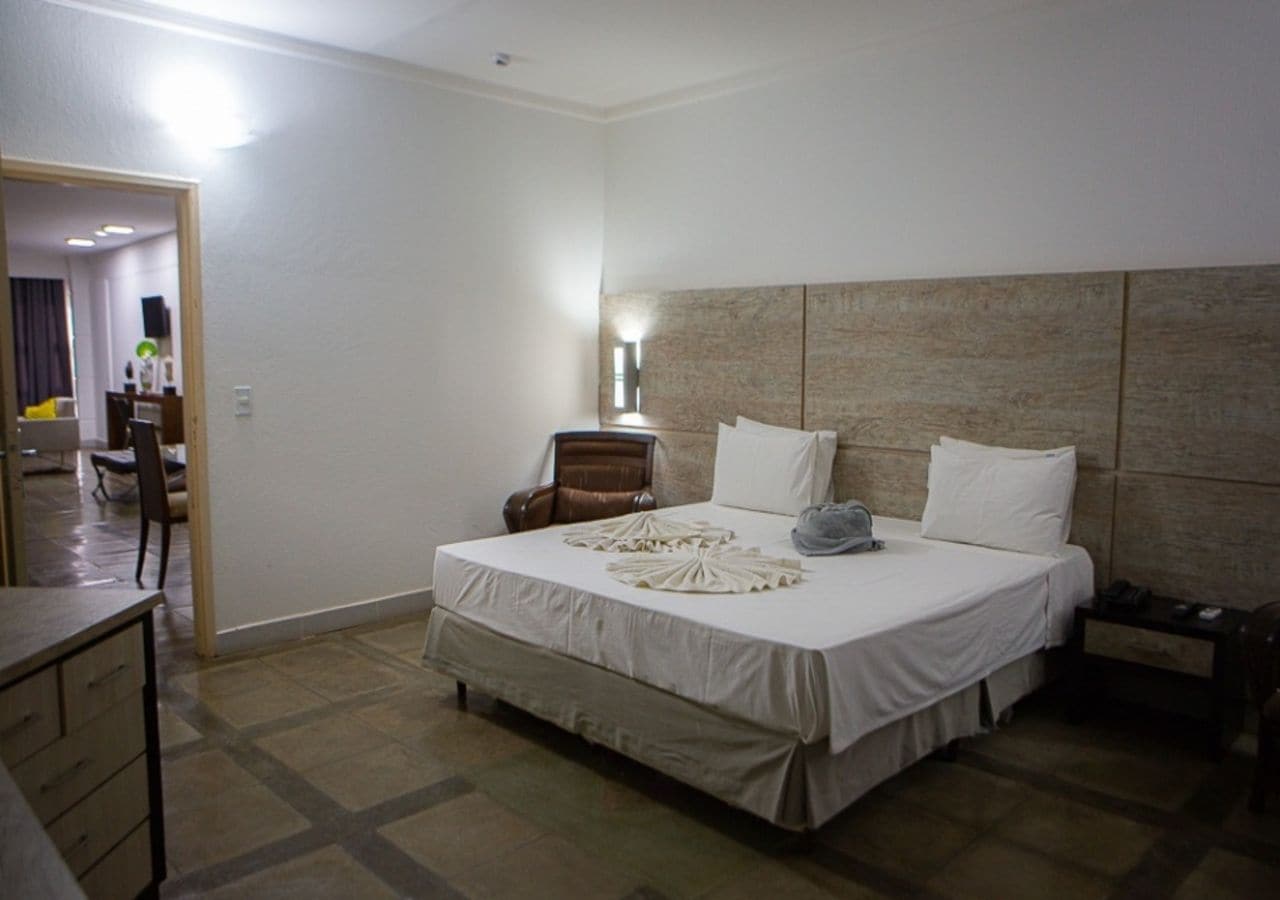A hotel room with a bed, a desk, and a chair.