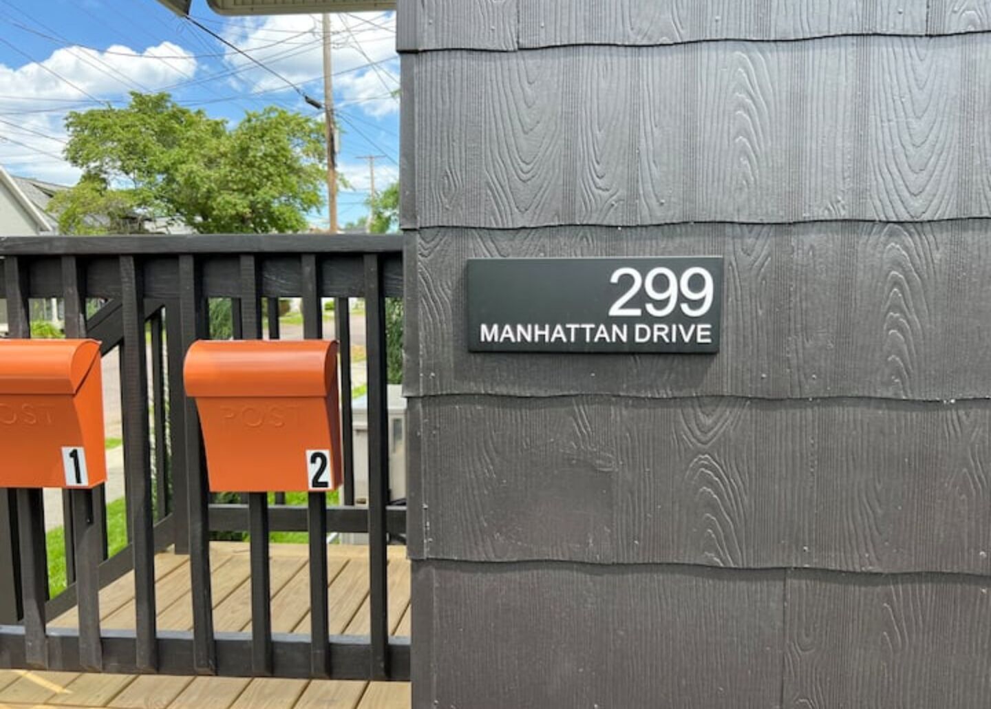 Une boîte aux lettres avec une plaque indiquant le numéro de la maison : 299, avenue Manhattan.