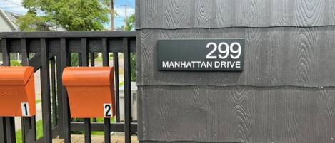 Une boîte aux lettres avec une plaque indiquant le numéro de la maison : 299, avenue Manhattan.