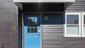 Eine blaue Tür mit Fenster, Briefkasten und der Hausnummer 2.
