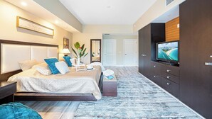 Une chambre moderne avec un grand lit, une télévision et une armoire.