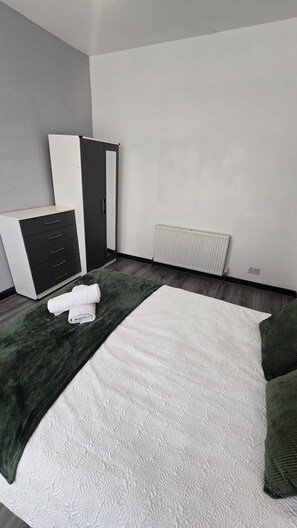 A bedroom with a bed, a wardrobe, a radiator, and a small table. - Entrepreneur Stays - 8 Guest Lovely home in Liverpool *NO GUEST FEE (Liverpool)