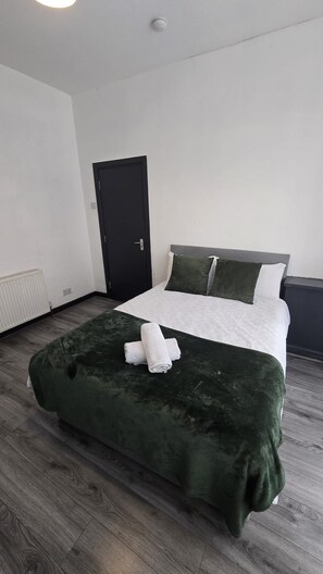 A hotel room with a bed, a door, and a radiator. - Entrepreneur Stays - 8 Guest Lovely home in Liverpool *NO GUEST FEE (Liverpool)