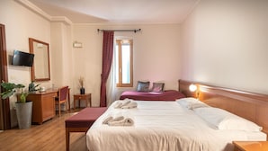 A hotel room with a bed, a desk, a chair, a TV, and a window with curtains. - Sottoassisi Guest House (Assisi)