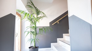 A potted plant in a modern hallway with a staircase and a handrail. - Sottoassisi Guest House (Assisi)