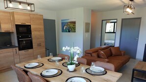 A modern kitchen with wooden cabinets and a built-in oven. - Gite in the heart of Senneville (Senneville-sur-Fécamp)