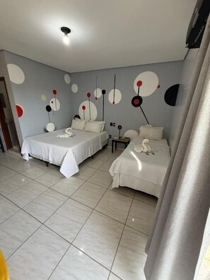A hotel room with two beds, a small table, and a wall with abstract art. - Hotel Avenida Plaza (Querencia)